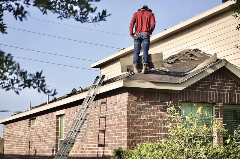 Professional roofer working on a residential roof in Collier City